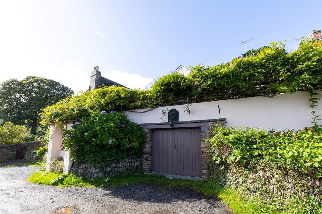 There is parking for one car, head up the steps under the wisteria to find your destination.
