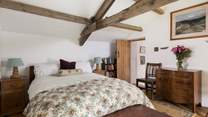 Original beams grace this cosy bedroom.