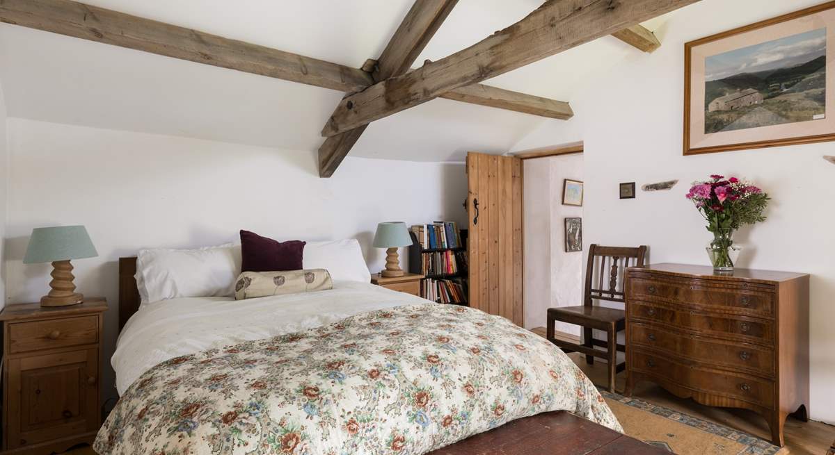 Original beams grace this cosy bedroom.