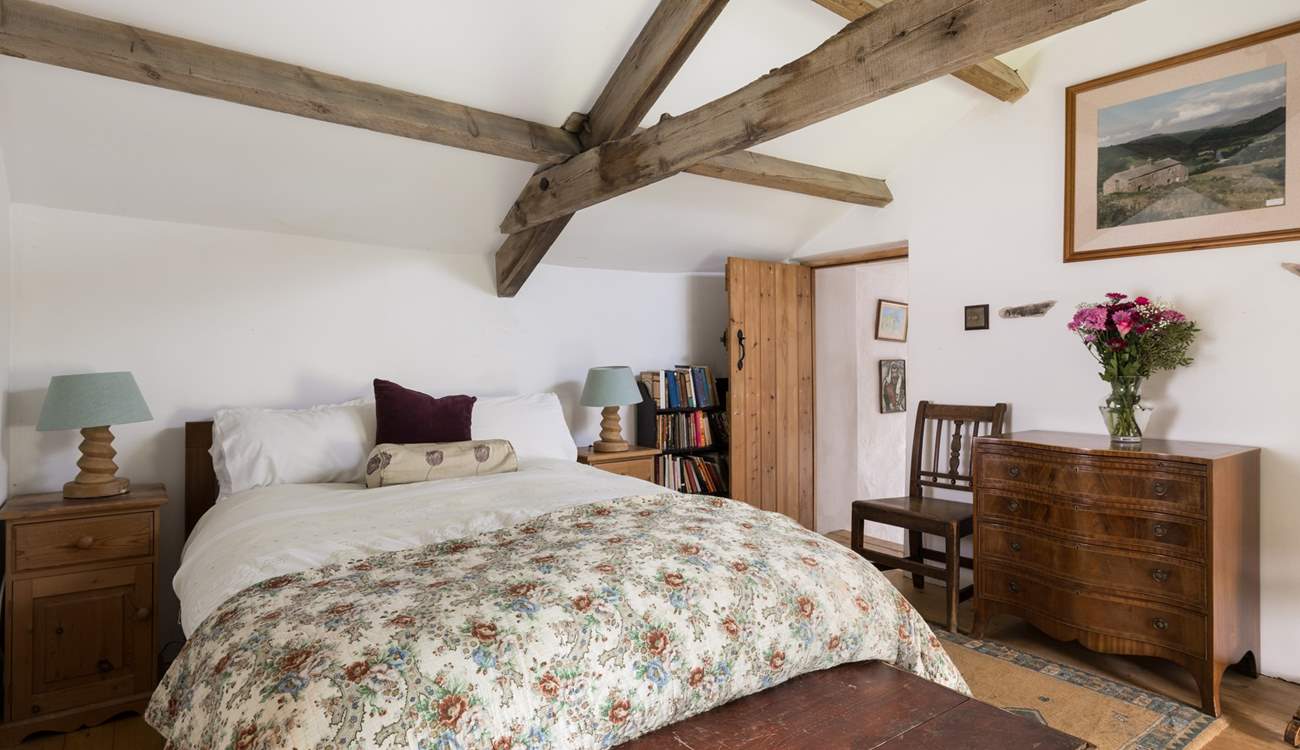 Original beams grace this cosy bedroom.
