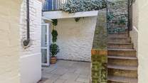 Steps lead down from the private parking-area to the enclosed courtyard.