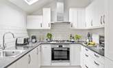 With its white and chrome cupboards the kitchen is as shiny as a new pin. - Thumbnail Image