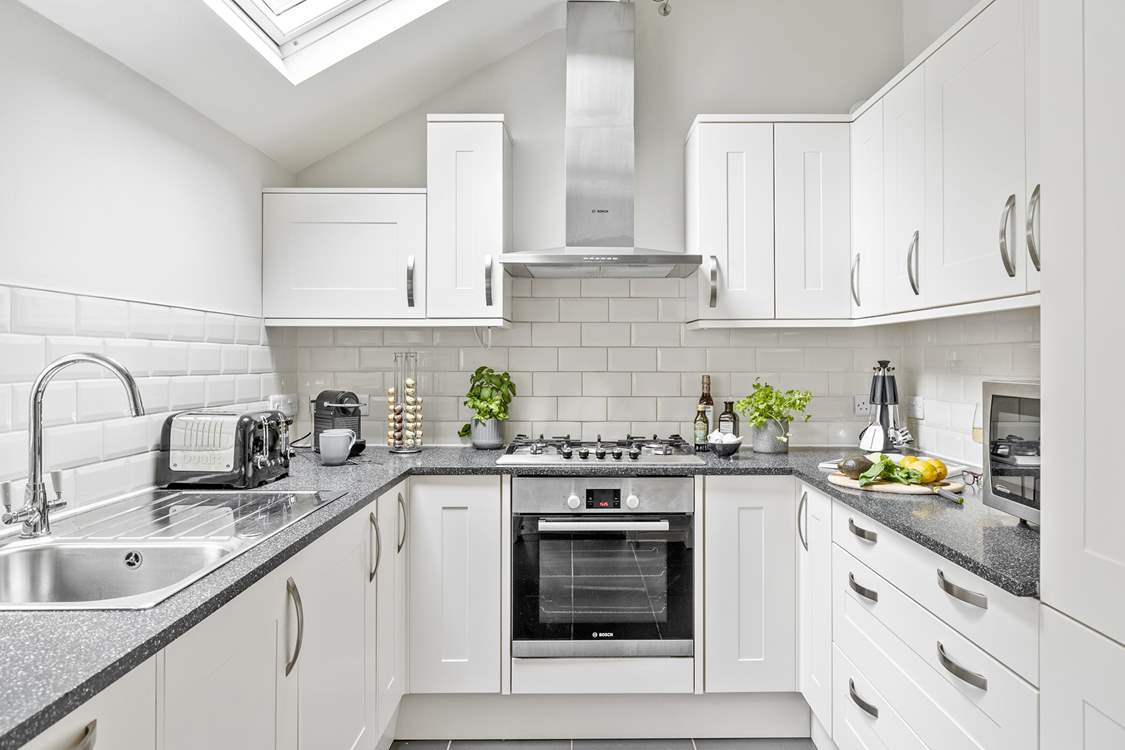 With its white and chrome cupboards the kitchen is as shiny as a new pin.