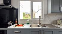 A kitchen which is light and airy, fresh and new, with a view of the pretty garden. 