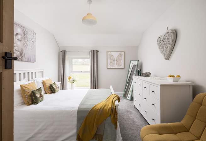 This pretty bedroom looks out over fields.