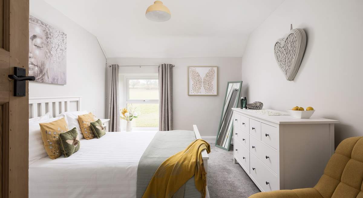 This pretty bedroom looks out over fields.