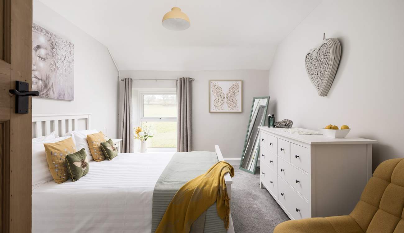 This pretty bedroom looks out over fields.