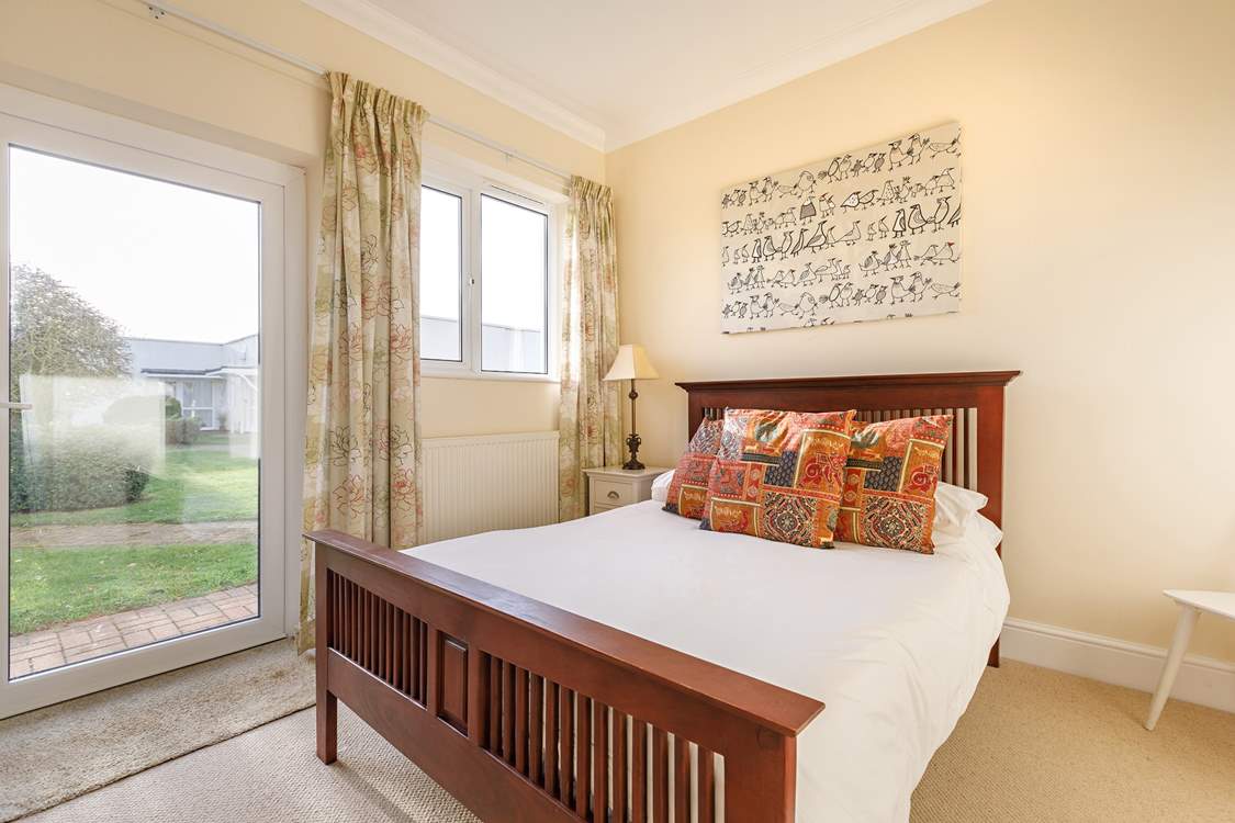 The ground floor double bedroom with a door leading to the communal garden.