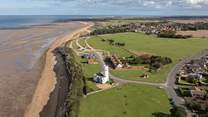 An aerial view of Hunstanton lighthouse and the changing tides of towards Old Hunstanton, minutes walk from Sandy Shores.