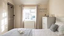 The sun shines in and bathes the bedroom in light. 