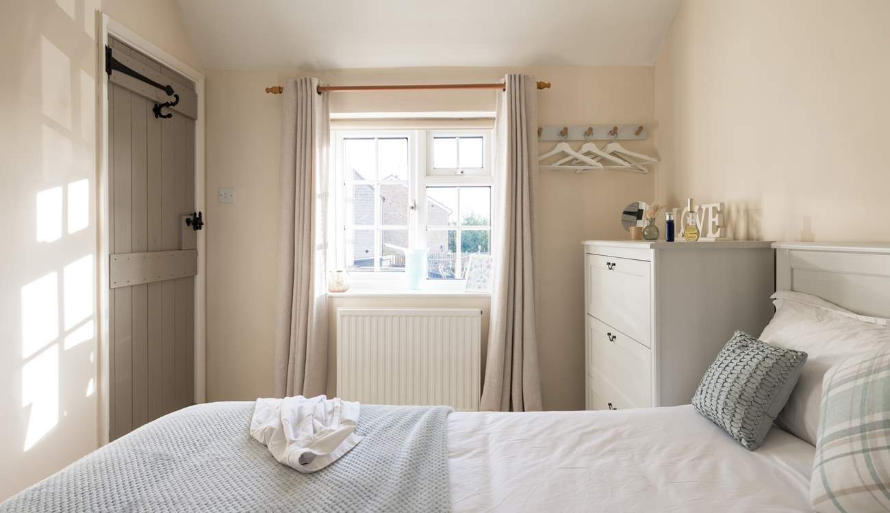 The sun shines in and bathes the bedroom in light. 