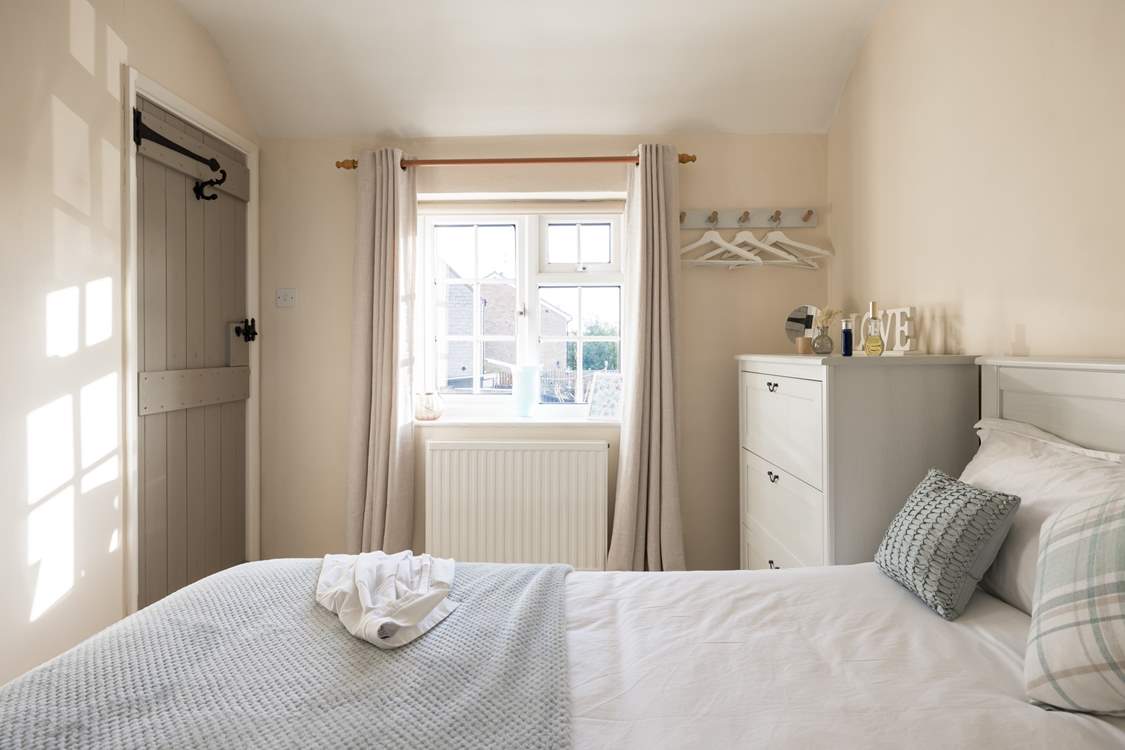 The sun shines in and bathes the bedroom in light.