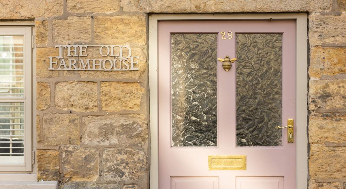 We just love the pink front door and cream stone façade. 