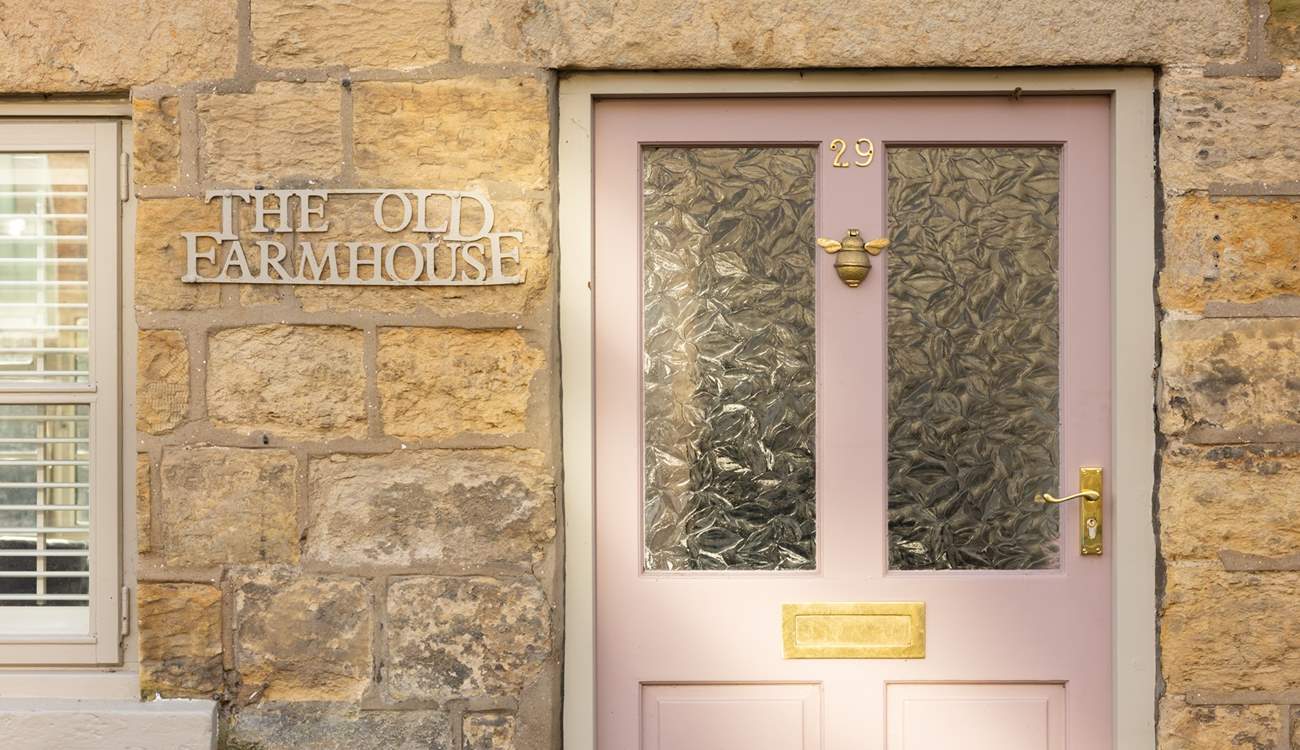 We just love the pink front door and cream stone façade. 