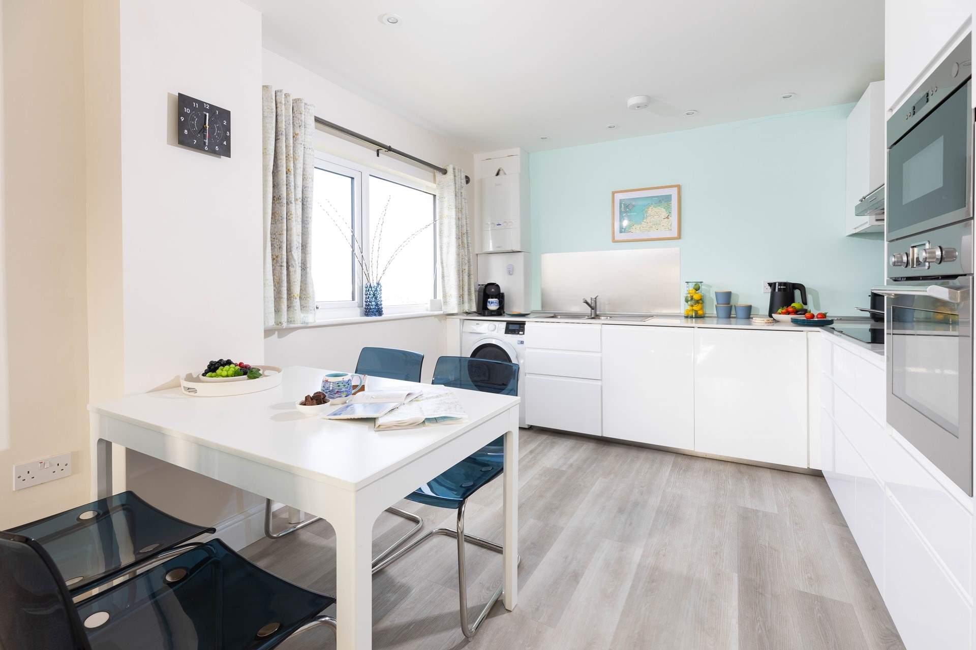 The sleek, fully equipped kitchen has a contemporary dining-table for sociable mealtimes.