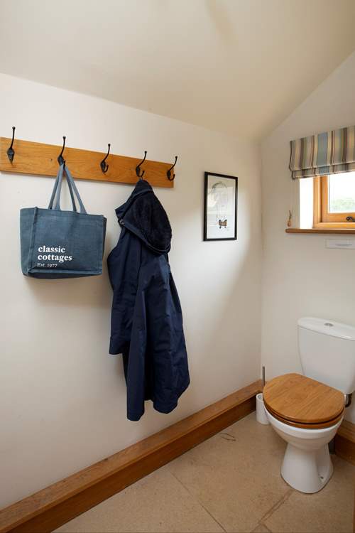 Ground floor cloakroom with space to hang bags and coats.