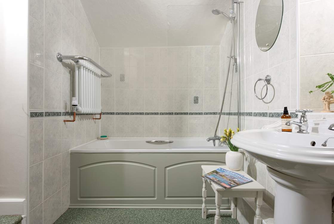 A bath complete with shower and heated towel rail.