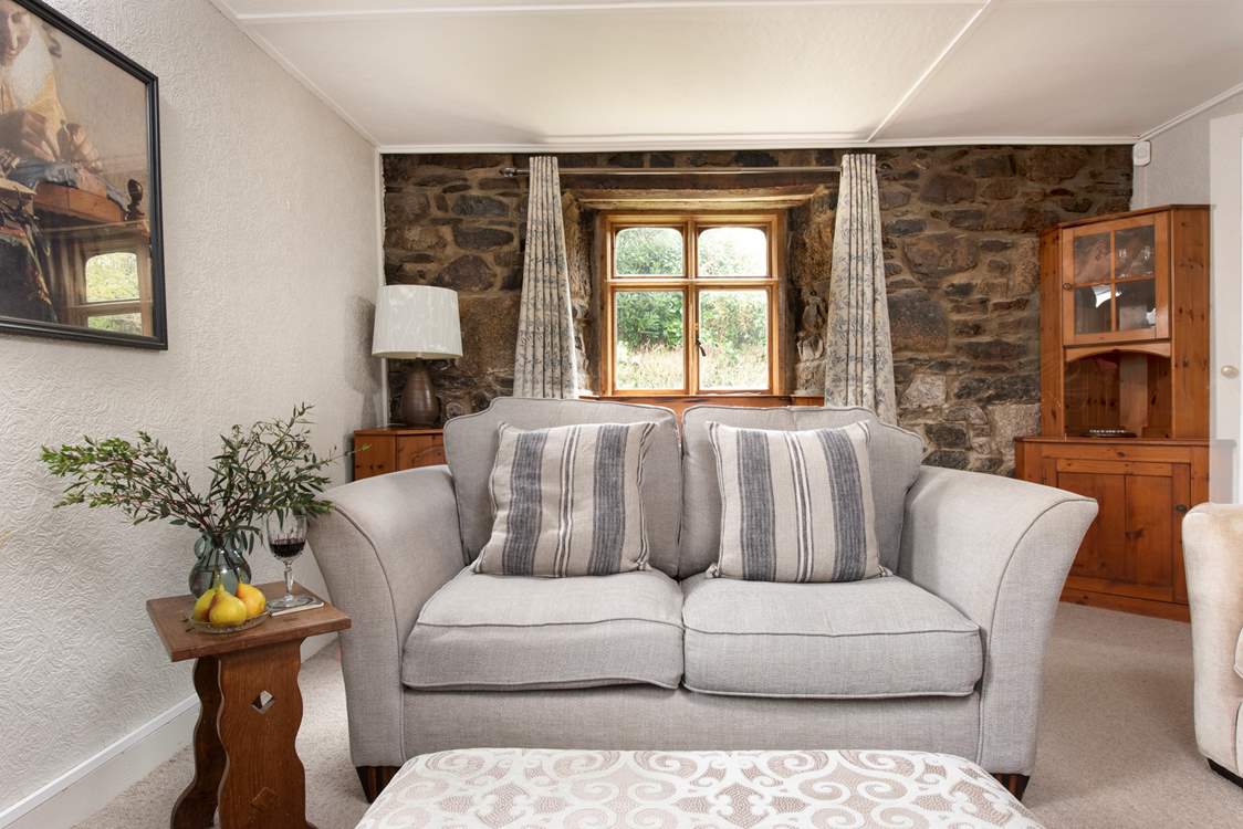 The sitting-room with its original windows overlook views of the trees that line the quiet lane.