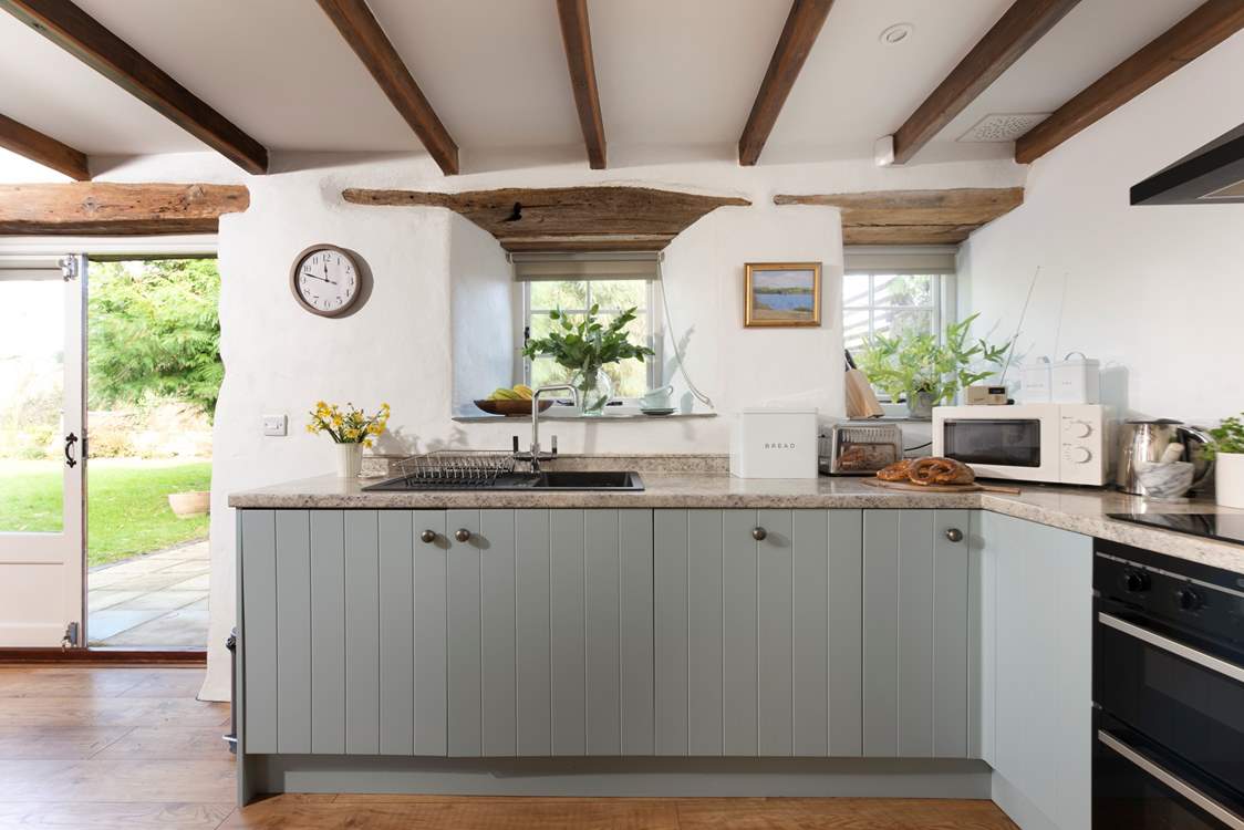 With wooden floors and rustic beams in the open plan area and a bespoke kitchen that is well-equipped for two lucky guests.