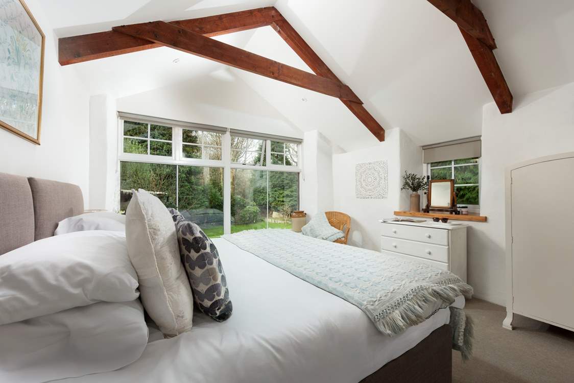 A stunning bedroom with king-size 'zip and link' luxury bed with views over the grounds and woodland beyond.