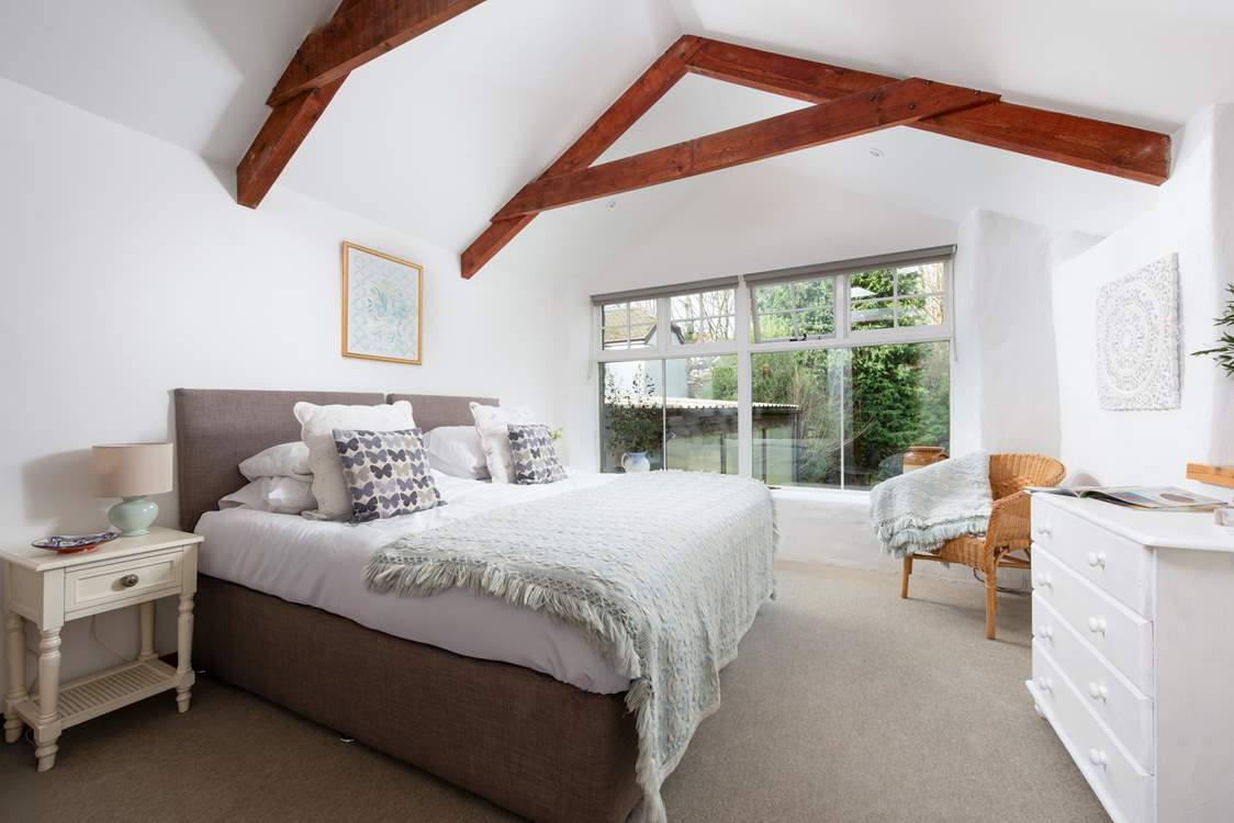 A charming bedroom with views of grounds. (The building attached to the stable is the owners' store room).