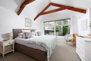 A charming bedroom with views of grounds. (The building attached to the stable is the owners' store room).