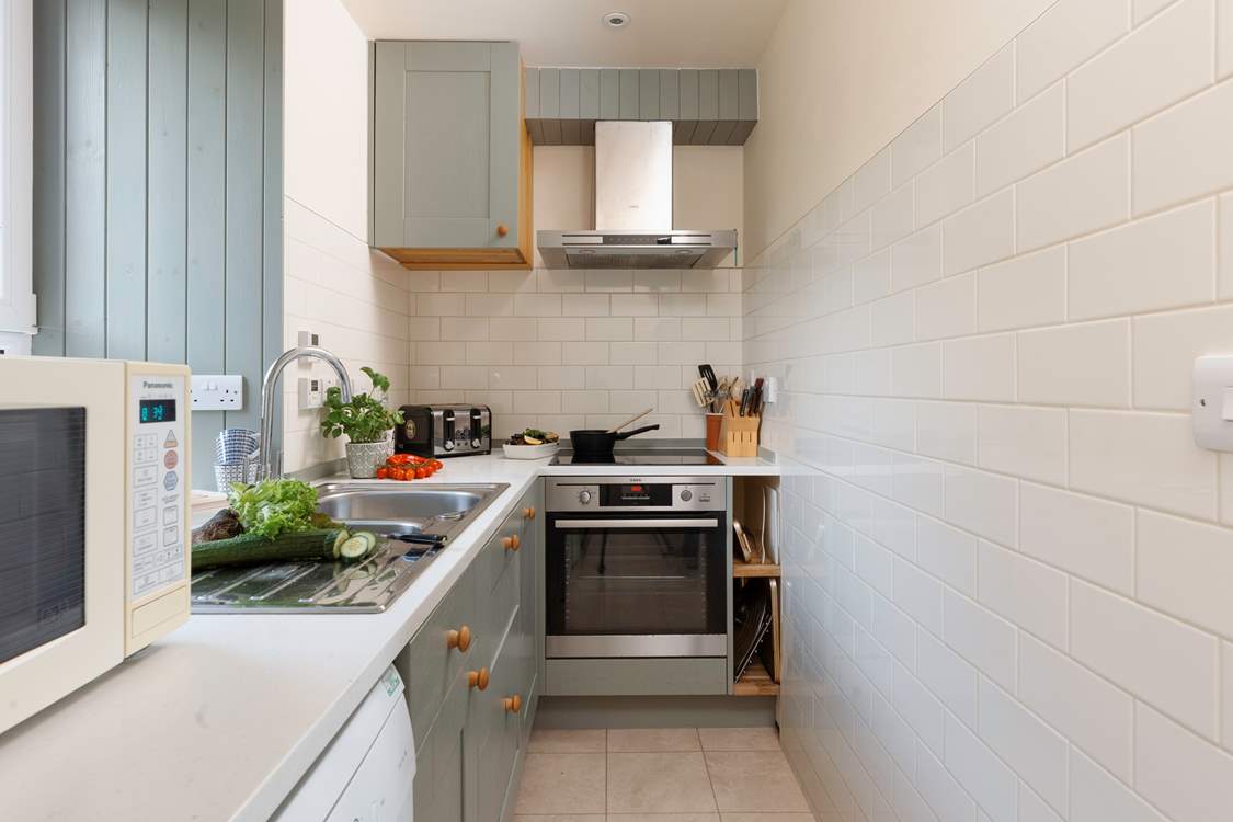 The modern kitchen is well-equipped and has a lovely view of the garden.