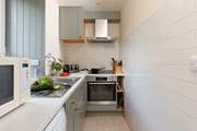 The modern kitchen is well-equipped and has a lovely view of the garden.