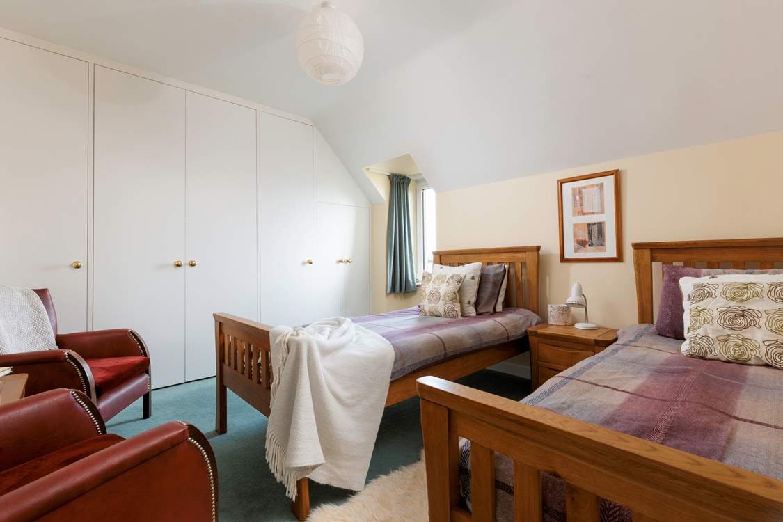 The spacious twin bedroom has fantastic views over the sea.