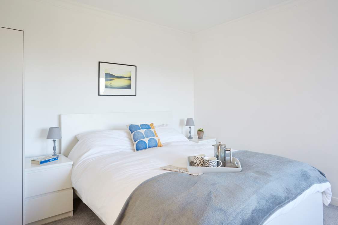 Bedroom 1 has a king-size bed and views towards the sea.