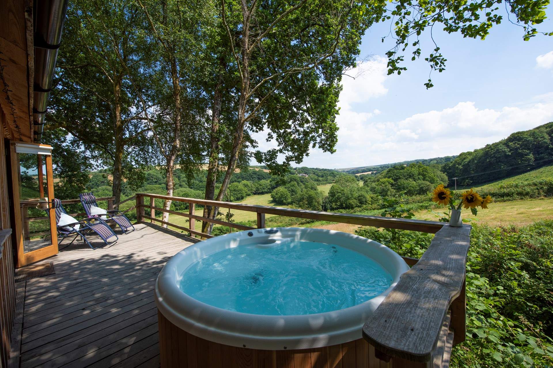 Where you can relax under the canopy of trees. (Please note the hot tub has been upgraded and a retractable cover has been added).