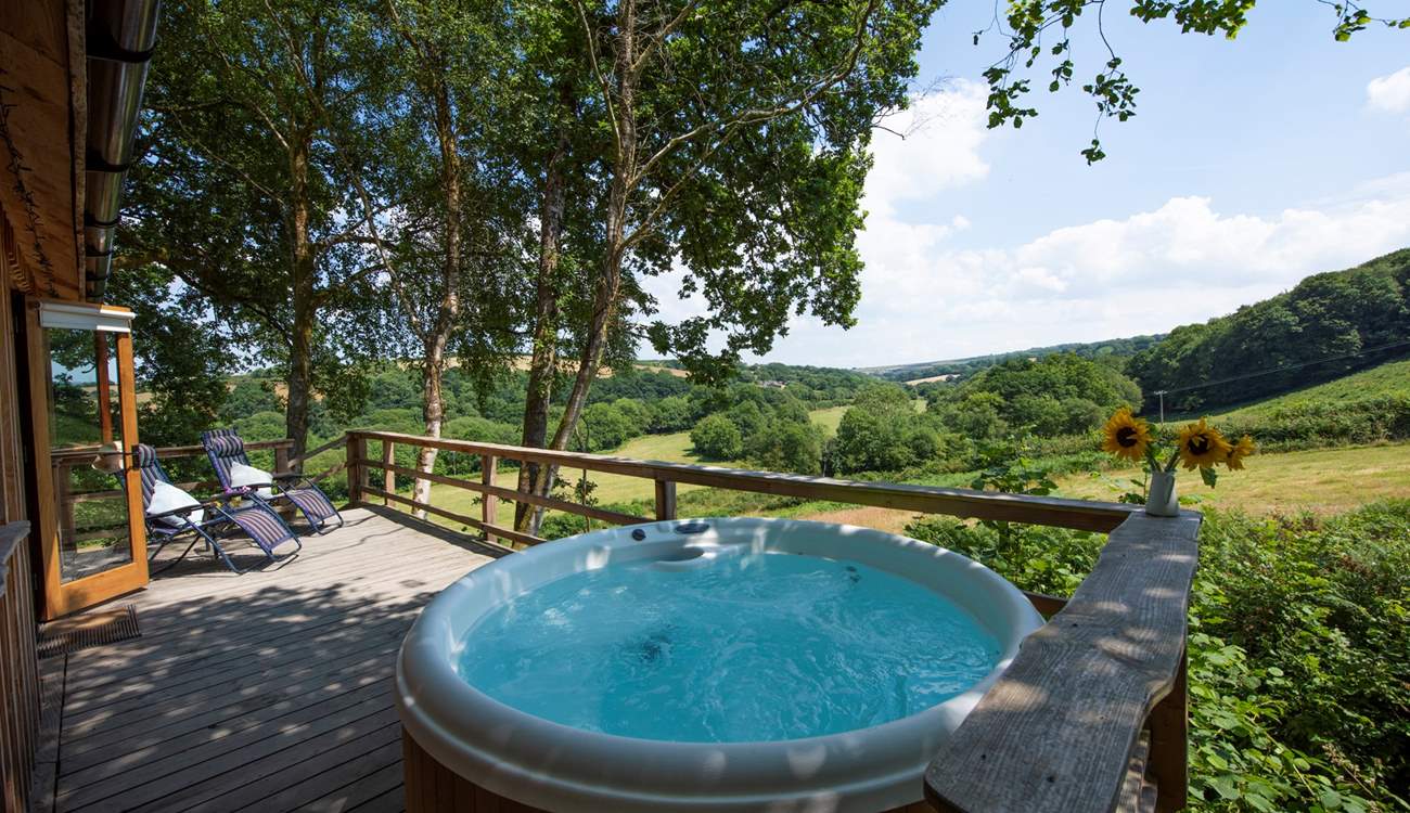Where you can relax under the canopy of trees. (Please note the hot tub has been upgraded and a retractable cover has been added).