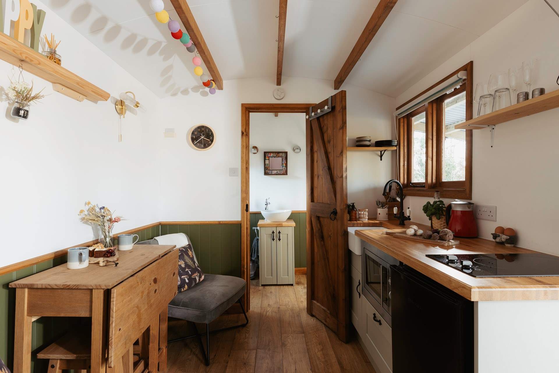 The light, airy space is filled with warm wooden accents and soothing splashes of sage green. 