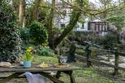 The main garden is set down by the river, accessed by the side of the garage. Please take care with young children,.