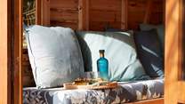 Cosy cushions and refreshments make for a peaceful moment in the summer-house.