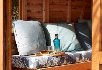 Cosy cushions and refreshments make for a peaceful moment in the summer-house.
