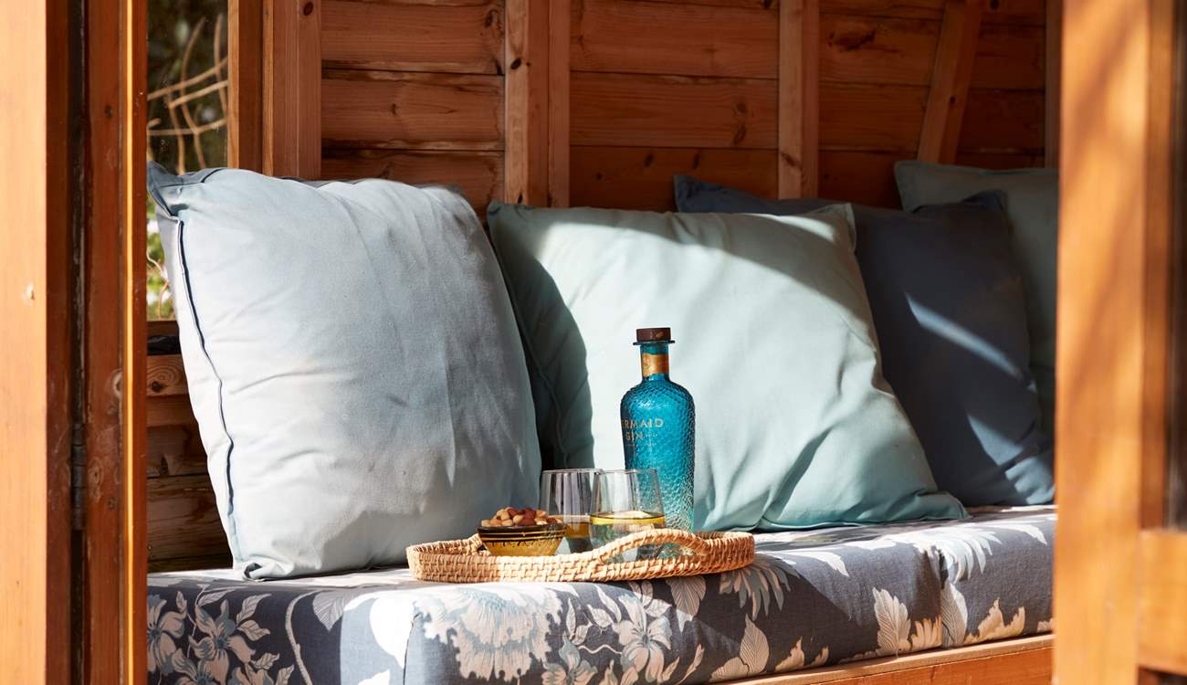 Cosy cushions and refreshments make for a peaceful moment in the summer-house.