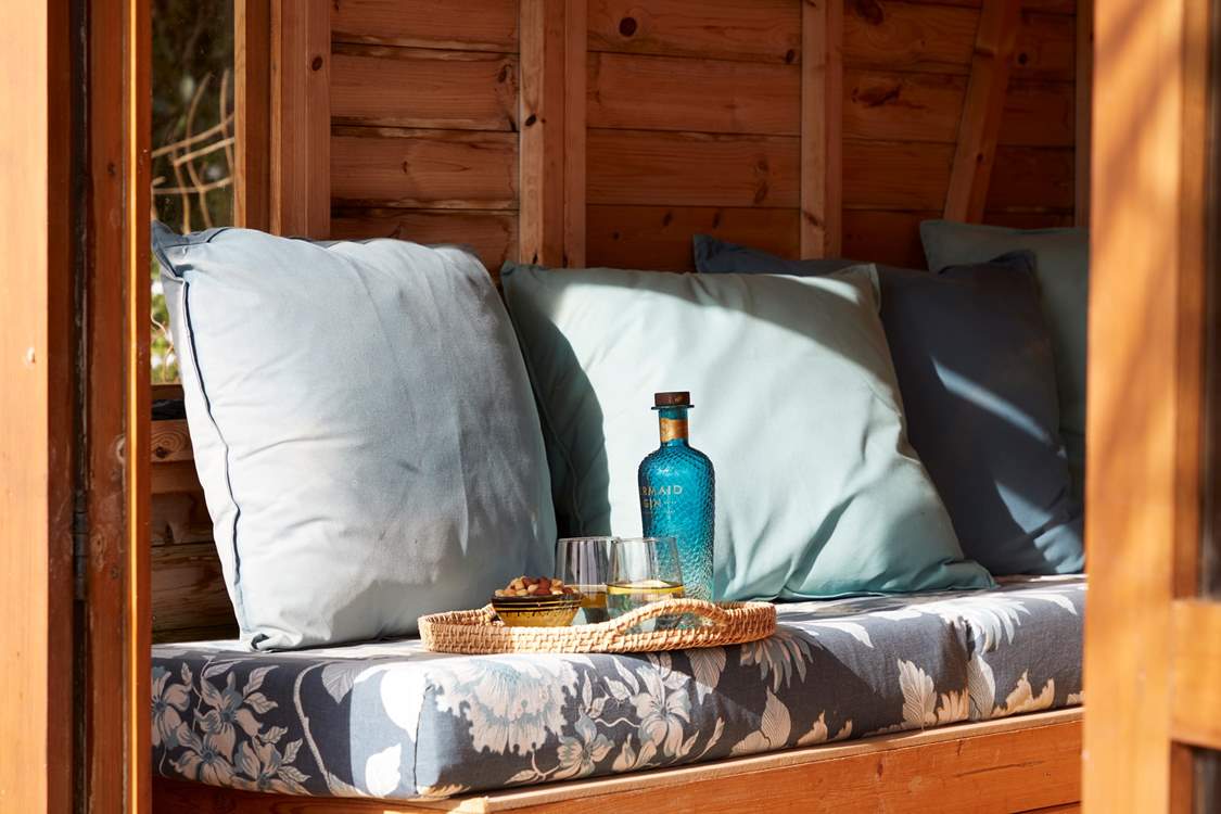 Cosy cushions and refreshments make for a peaceful moment in the summer-house.