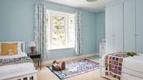 A comfortable space for rest and play in this spacious twin bedroom. 