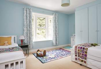 A comfortable space for rest and play in this spacious twin bedroom. 