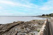 Opposite, the sea laps gently on the shoreline.