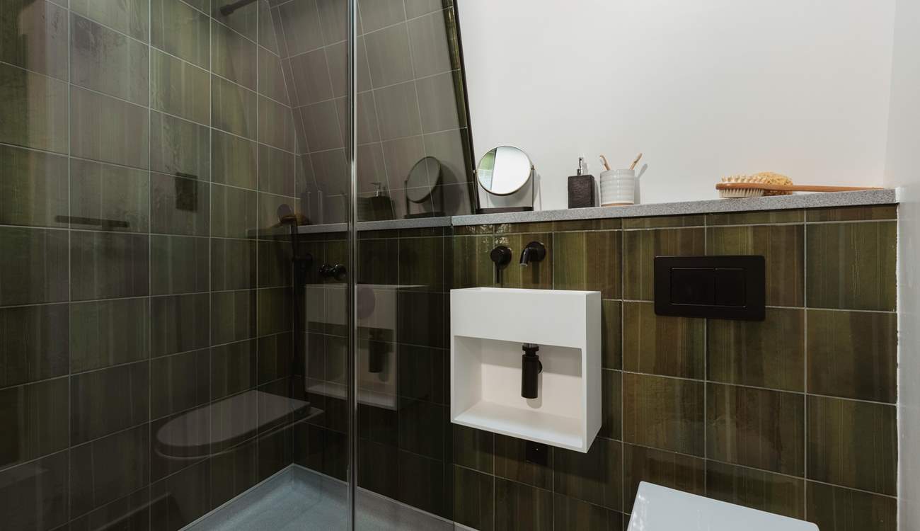 The green hues of the shower-room pair perfectly with the woodland surroundings.
