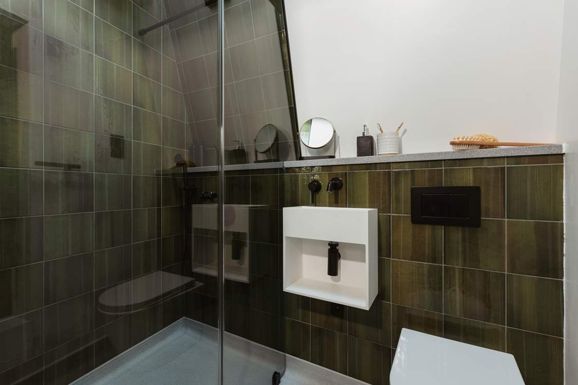 The green hues of the shower-room pair perfectly with the woodland surroundings.
