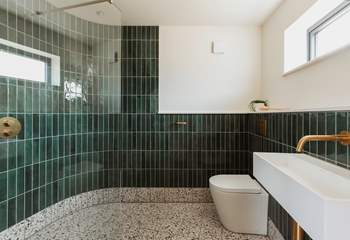 Emerald green tiles and splashes of gold give the shower room a spa-like feel.