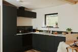 The sleek kitchen is thoughtfully equipped with everything you could need.