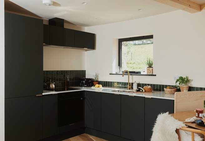 The sleek kitchen is thoughtfully equipped with everything you could need.