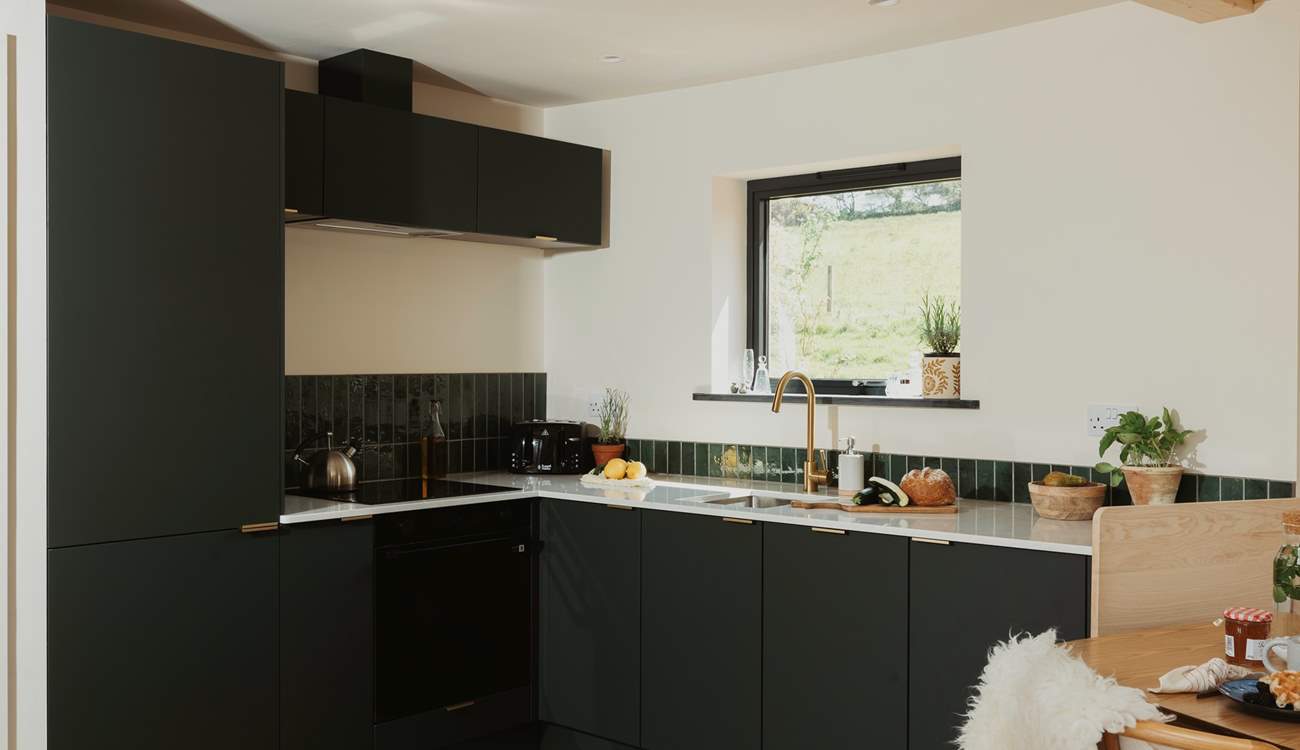 The sleek kitchen is thoughtfully equipped with everything you could need.