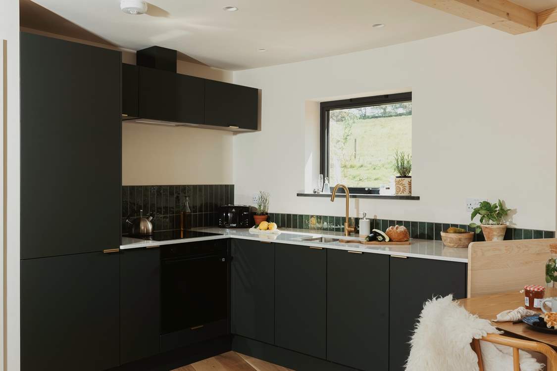 The sleek kitchen is thoughtfully equipped with everything you could need.