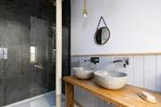 The family shower-room has high ceilings and double sinks.