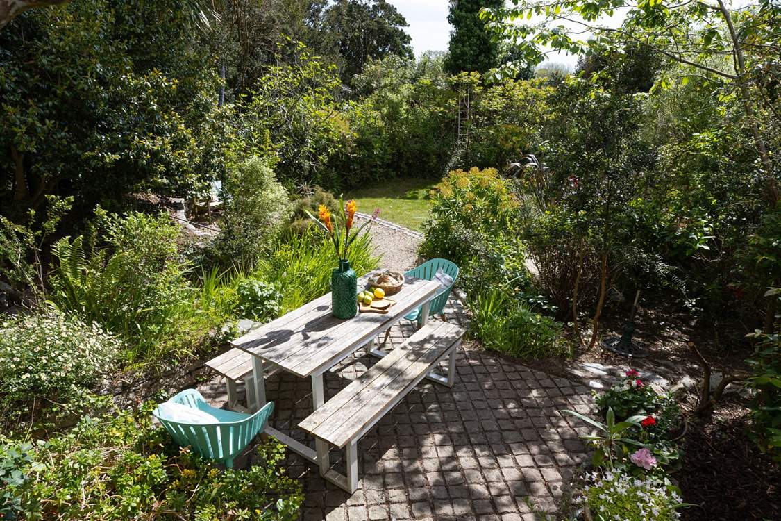 The dining table is in dappled sunlight, perfect for those long relaxing lunches.